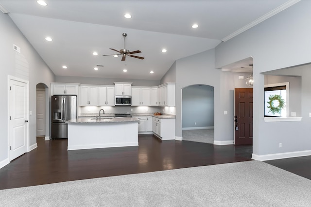 kitchen featuring stainless steel appliances, an island with sink, ceiling fan, sink, and white cabinetry