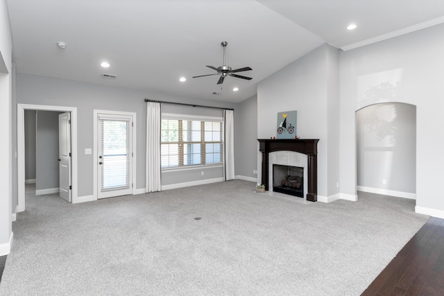 unfurnished living room featuring carpet, ceiling fan, vaulted ceiling, and ornamental molding