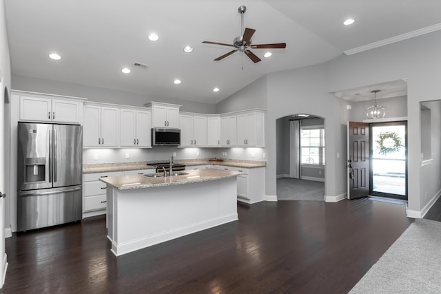 kitchen with stainless steel appliances, hanging light fixtures, light stone countertops, white cabinetry, and ceiling fan with notable chandelier