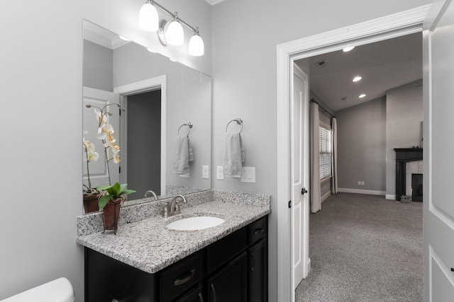 bathroom featuring a tile fireplace and vanity