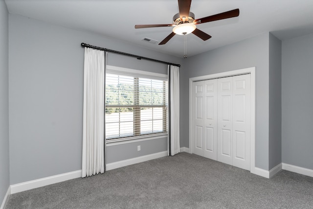 unfurnished bedroom with ceiling fan, a closet, and carpet flooring