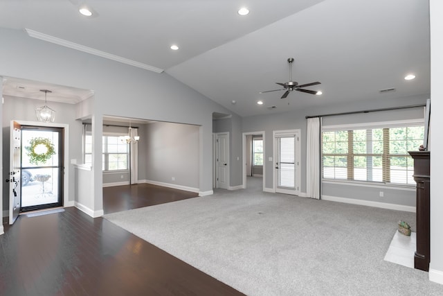 unfurnished living room with lofted ceiling, ceiling fan with notable chandelier, ornamental molding, and a wealth of natural light