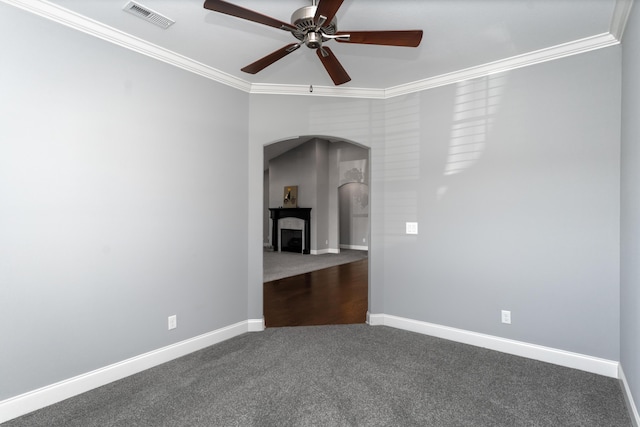 empty room featuring ceiling fan, crown molding, and carpet