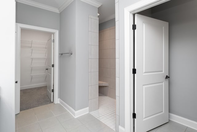 bathroom featuring a tile shower, tile patterned flooring, and ornamental molding