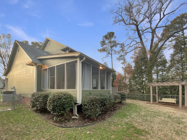 view of side of property featuring a sunroom and a yard