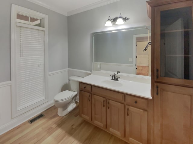 bathroom with hardwood / wood-style floors, vanity, toilet, and crown molding