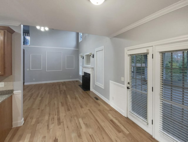 unfurnished living room featuring light hardwood / wood-style floors and ornamental molding