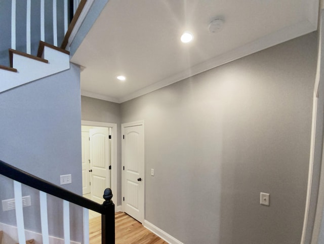 corridor featuring hardwood / wood-style floors and crown molding