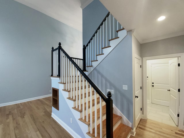 stairway featuring hardwood / wood-style flooring and crown molding