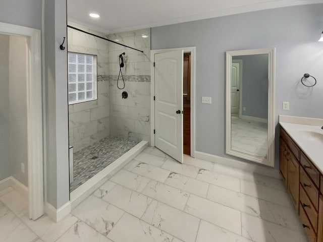 bathroom with tiled shower and vanity