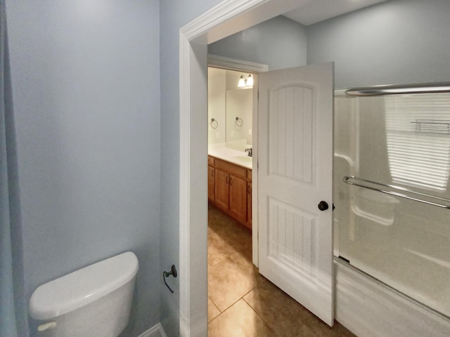 bathroom with tile patterned flooring, toilet, an enclosed shower, and vanity