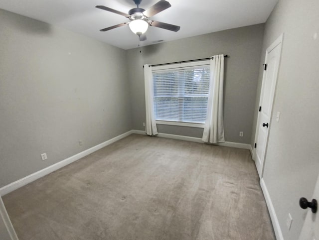 spare room with ceiling fan and light colored carpet