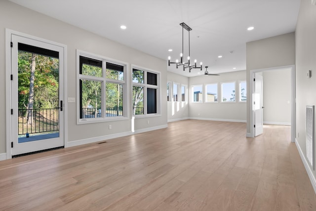 interior space featuring a healthy amount of sunlight, light hardwood / wood-style flooring, and ceiling fan with notable chandelier