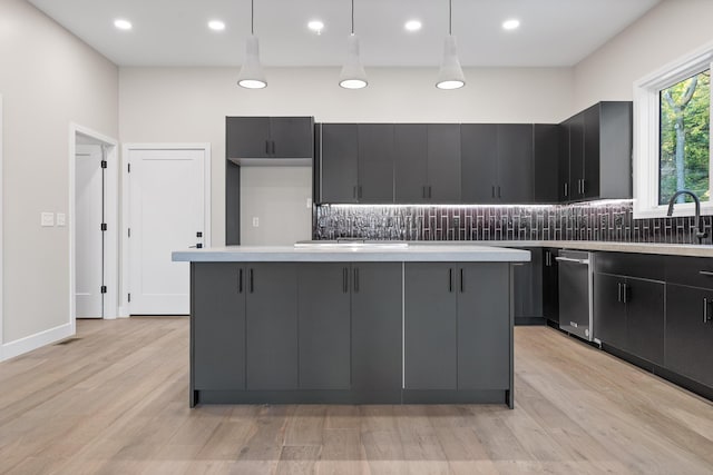 kitchen with a center island, light hardwood / wood-style flooring, decorative light fixtures, and decorative backsplash