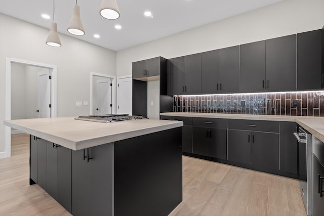 kitchen featuring stainless steel appliances, light hardwood / wood-style flooring, decorative light fixtures, and a kitchen island