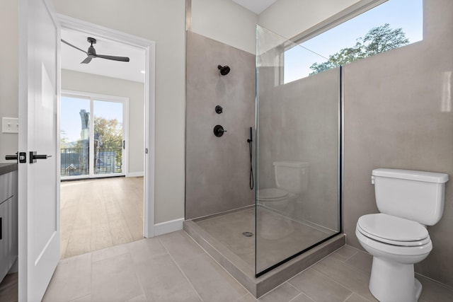 bathroom featuring ceiling fan, tiled shower, tile patterned floors, and toilet