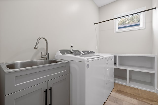 laundry room with sink, light hardwood / wood-style flooring, cabinets, and independent washer and dryer