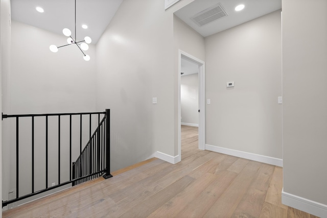 hallway with a chandelier and light hardwood / wood-style flooring