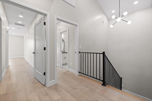 corridor featuring light hardwood / wood-style floors and a notable chandelier