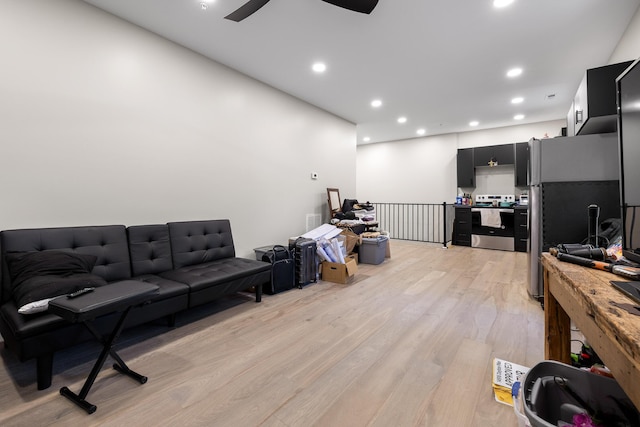 living room with ceiling fan and light hardwood / wood-style flooring