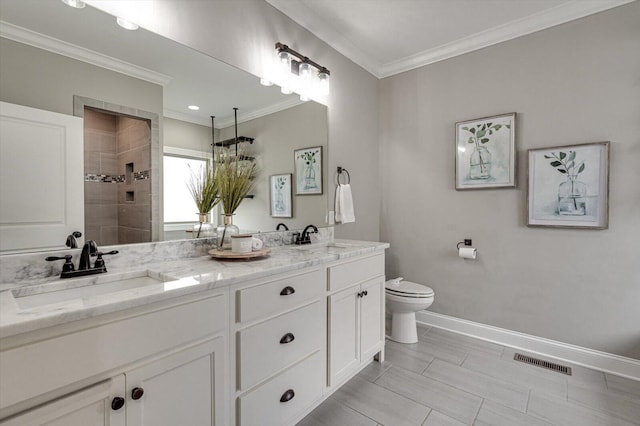 bathroom featuring toilet, tiled shower, vanity, and crown molding