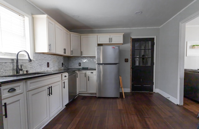 kitchen with sink, white cabinetry, stainless steel appliances, dark hardwood / wood-style floors, and tasteful backsplash