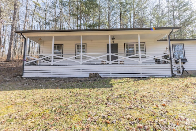 back of house featuring a yard and covered porch