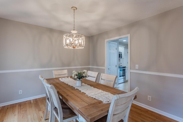 dining area featuring light wood-type flooring and a chandelier