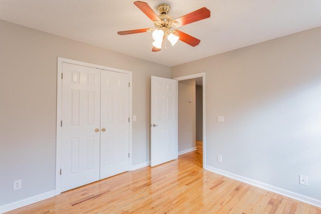 unfurnished bedroom featuring ceiling fan, light wood-type flooring, and a closet