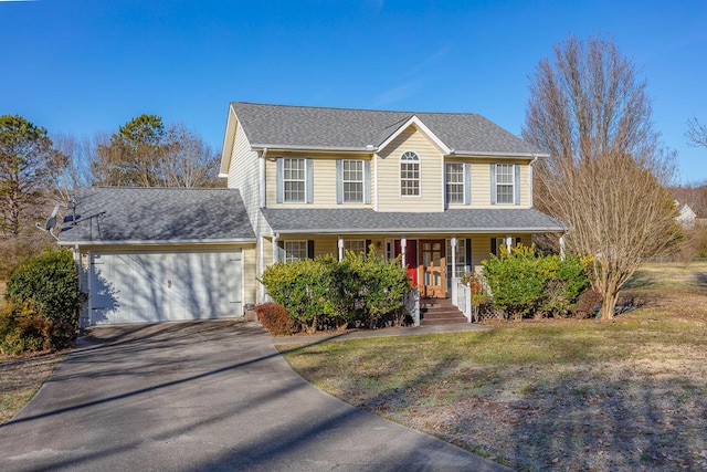 view of front facade featuring a front yard, a garage, and covered porch