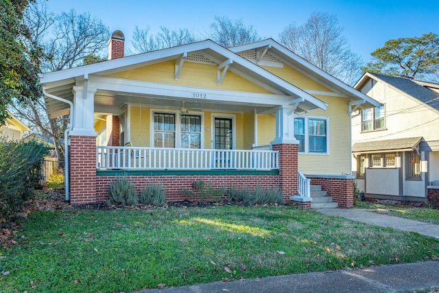 view of front of house with a porch and a front lawn