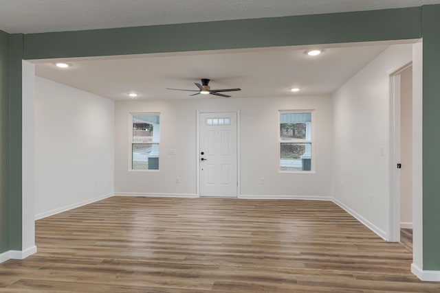 foyer with ceiling fan, a healthy amount of sunlight, a textured ceiling, and wood-type flooring