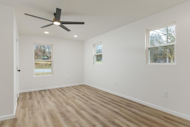 spare room with light wood-type flooring and ceiling fan