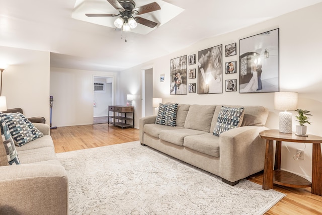 living room with ceiling fan, wood-type flooring, and a wall mounted air conditioner