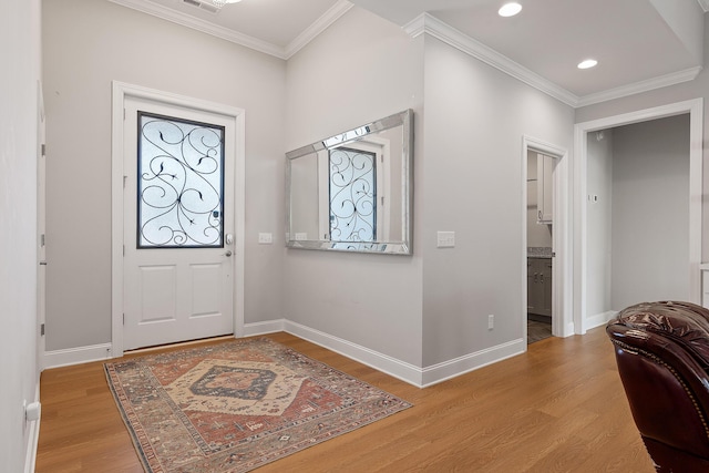 entrance foyer with ornamental molding and light hardwood / wood-style floors