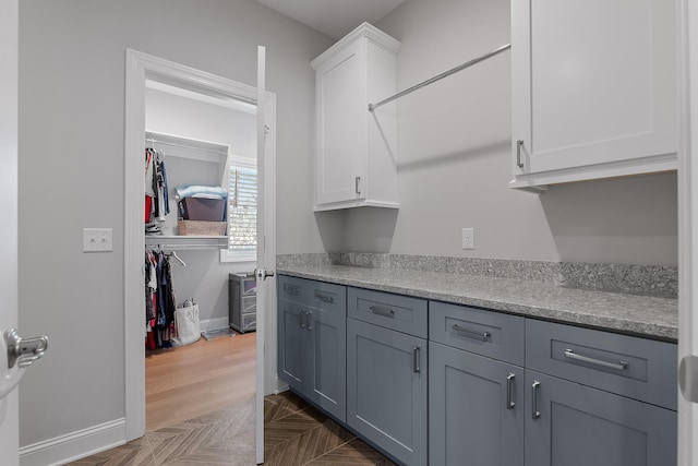 kitchen with gray cabinets, white cabinets, and dark parquet floors