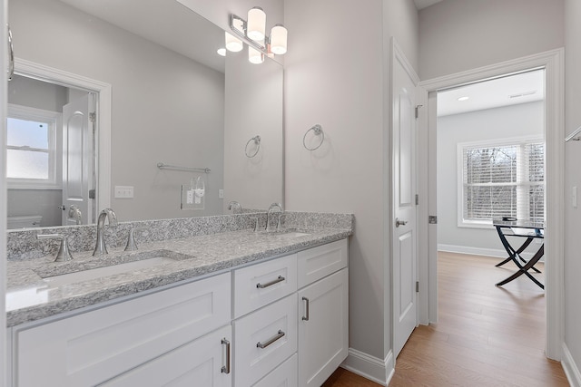 bathroom featuring vanity, hardwood / wood-style floors, plenty of natural light, and toilet