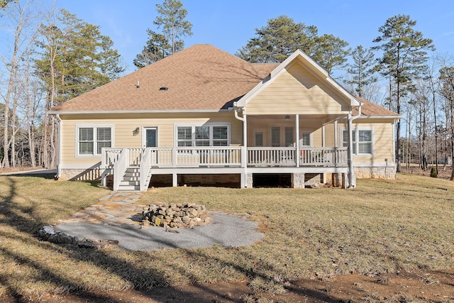 rear view of property with a deck and a lawn