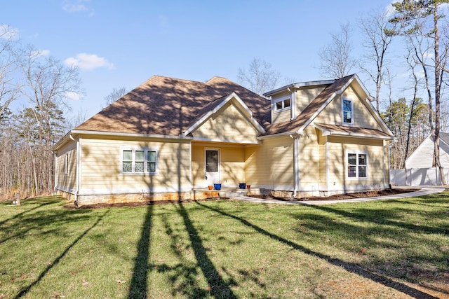 view of front of house featuring roof with shingles and a front yard