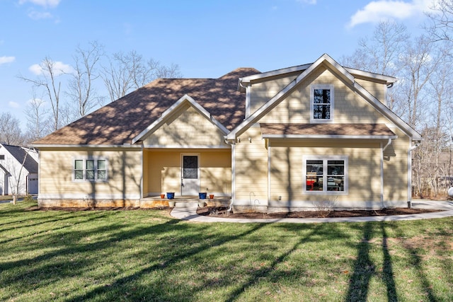 view of front of home with a front yard and a shingled roof