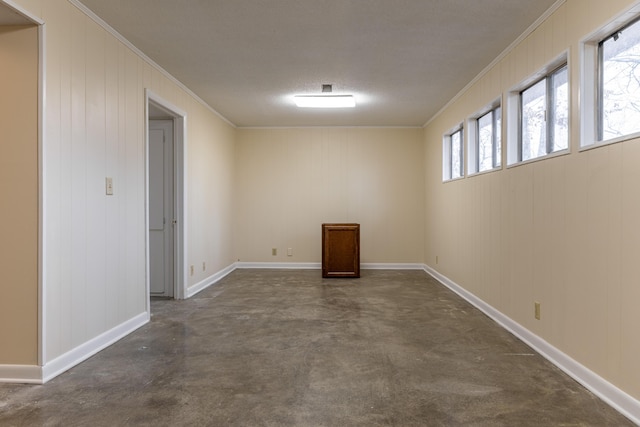 unfurnished room with crown molding and wooden walls