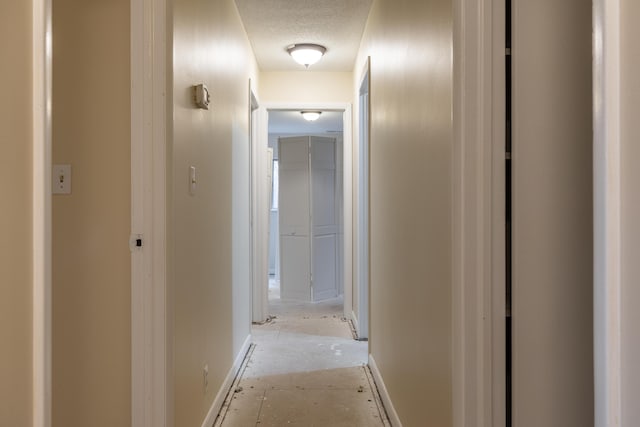 hall featuring a textured ceiling