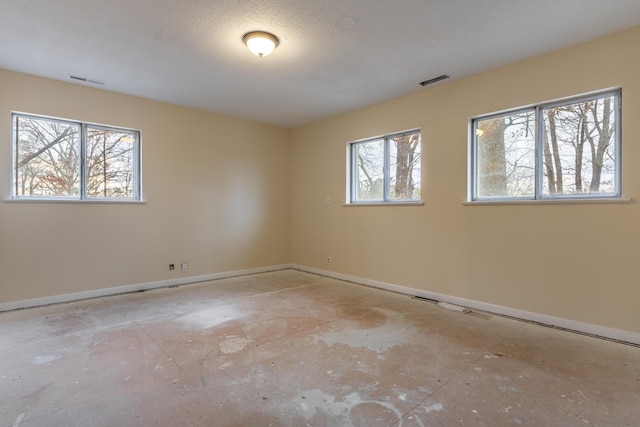 unfurnished room with a healthy amount of sunlight and a textured ceiling