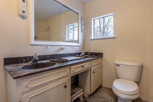 bathroom featuring vanity, toilet, and a shower