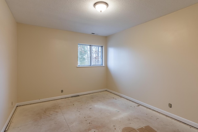 unfurnished room featuring a textured ceiling