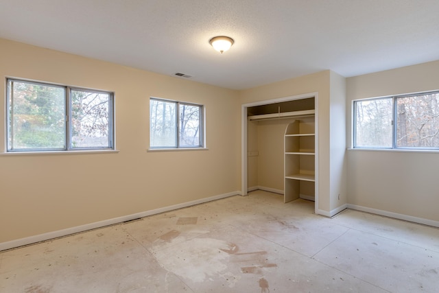 unfurnished bedroom with multiple windows and a closet