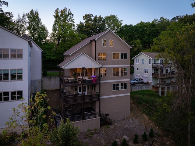 back of property with a balcony and a garage