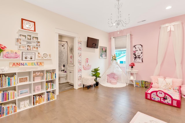 game room with a chandelier and hardwood / wood-style flooring