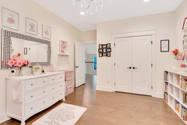 interior space featuring an inviting chandelier, a closet, and light hardwood / wood-style flooring