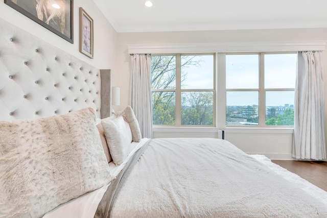 bedroom with crown molding, multiple windows, and hardwood / wood-style floors